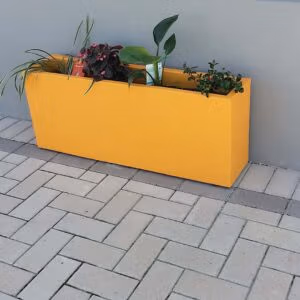 A Trough Planter Filled With Flowers And Plants