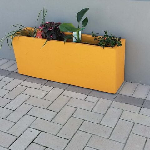 A trough planter filled with flowers and plants